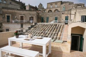 a white table and bench on top of a building at Le Tre Vie Apartment & Room in Matera