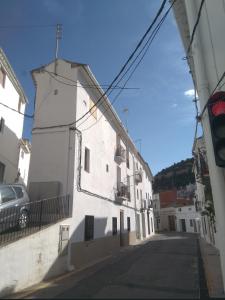 a white building with a car parked on a street at Casa Rural La Tia Rosa in Chulilla