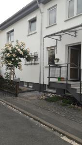 ein weißes Haus mit einer Veranda und einem Balkon in der Unterkunft Zimmer Frei in Wiesbaden + 13 Fotos