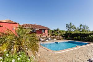 a villa with a swimming pool in front of a house at La Verada in Puntagorda