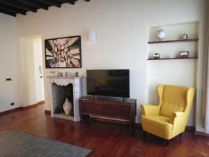 a living room with a television and a chair and a fireplace at Inappartamento Diamante in Turin