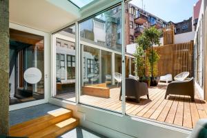a room with glass doors and a deck with chairs at The A5 Smart Luxury Studios in Porto