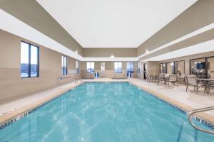 a pool in a hotel with tables and chairs at Candlewood Suites Fargo South-Medical Center by IHG in Fargo