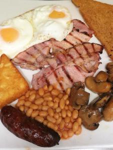 a plate of breakfast food with eggs bacon beans and toast at The Tudor Hotel in Bridgwater