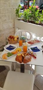 una mesa cubierta con platos de comida y zumo de naranja en B&B Torrente Antico, en Trani