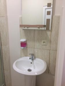 ein Badezimmer mit einem weißen Waschbecken und einem Spiegel in der Unterkunft guest house QEDI in Jvari