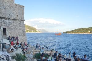 a group of people sitting on steps next to a body of water at Villa Madonna della Strada A3 in Dubrovnik