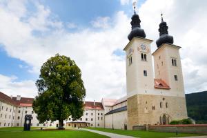 a large white building with a clock tower at JUFA Hotel Stift Gurk in Gurk