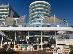a large building with tables and chairs in front of it at White Tower Mamaia - Private Apartment in Mamaia
