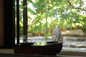 竹富町にある竹富島　茜屋の窓前のガラス二杯付きテーブル