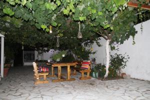 a picnic table and two chairs under a tree at Kondilw Rooms in Kalamitsi