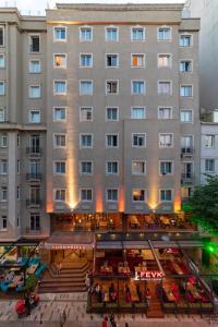 Four Sides Taksim Lion Hotel&Spa في إسطنبول: مبنى كبير أمامه فناء