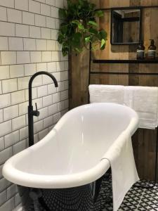 baño con bañera blanca y planta en The Boathouse, en Londres 19 fotos más