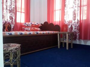 a bed in a room with red curtains at Vamoose Nilakanta in Sukhia Pokhari