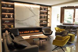ein Wohnzimmer mit einem Sofa, Stühlen und einem Kamin in der Unterkunft Hotel Federale in Lugano