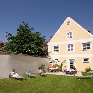 a group of people sitting in lawn chairs in front of a house at Hotel Zur Krone in Beilngries