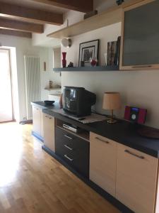 een keuken met een aanrecht met een magnetron en een televisie bij Lausen Vil in Canale San Bovo