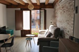 a living room with a couch and a brick wall at Apartamentos La Alborada Medieval in Ayllón
