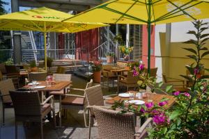 a patio area with tables, chairs and umbrellas at Star Inn Hotel Premium Graz in Graz