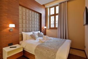 um quarto de hotel com uma cama e uma janela em Hotel Passpartù Home Garni em Belgrado