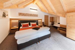 a bedroom with a large bed with orange pillows at Sport Garni Kapplerhof – Ischgl/Kappl in Kappl