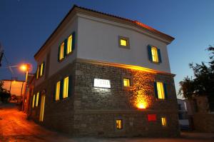 een bakstenen gebouw met 's nachts verlichte ramen bij Çeşme Kale Taş Apart in Çeşme