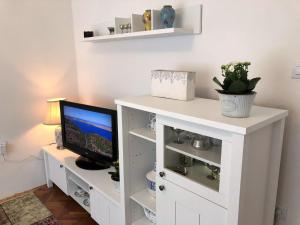 een wit computerbureau met een monitor en een televisie bij Apartment Ilija in Zadar