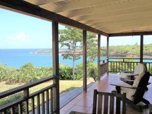 un porche con vistas al océano en Two Bays Beach Villa, Apartment, and Studios, en Crochu