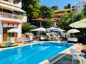 a pool at a hotel with chairs and umbrellas at Rooms Olympia in Gialiskari