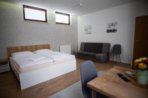 1 dormitorio con cama, sofá y mesa en Ubytovanie Alej Bojnice en Bojnice