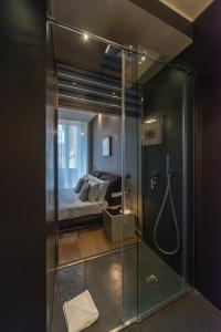 a glass shower in a bedroom with a bed at Campo Marzio Luxury Suites in Rome