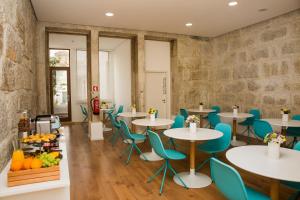 a restaurant with tables and blue chairs and fruit at BO - Álvares Cabral GuestHouse in Porto