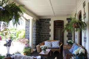 a woman walking on the porch of a house at Historic Merryville Homestead in Murrumbateman +7 photos