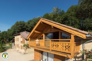 ein großes Holzhaus mit Balkon in der Unterkunft Chalet le Clos de l'Orme in Saint-Lattier
