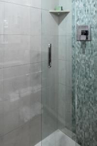 een douche met een glazen deur bij Bell Tower Hotel in Ann Arbor