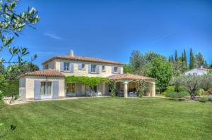 una casa con un gran patio con césped verde en Villa Indigo, en Saint-Rémy-de-Provence