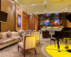 um átrio do hotel com um piano e um bar em Marco Polo Parkside, Beijing em Pequim