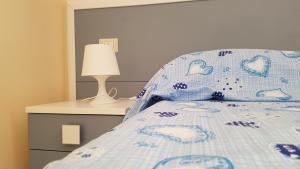 a bedroom with a bed with a blue comforter and a lamp at Il Moro della Molpa in Palinuro