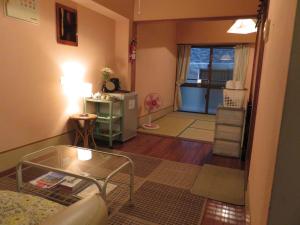 a living room with a glass table and a living room at Hostel Hakuseiso in Naha