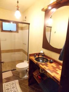 a bathroom with a sink and a toilet and a mirror at Chalé Estilo Alemão - Centro de Canela in Canela