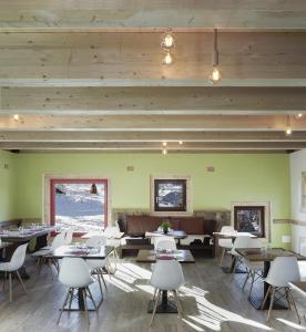 サウゼ・ドゥルクスにあるRestaurant Hotel Chalet Del Soleのダイニングルーム(テーブル、白い椅子付)