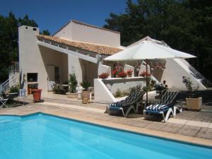 een huis met een zwembad en twee stoelen en een parasol bij JAS en Provence in Plan dʼAups