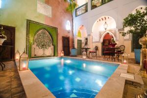 a large swimming pool in a room with a house at Riad Caesar in Marrakech