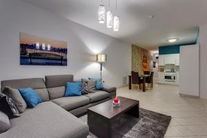 een woonkamer met een bank en een tafel bij Modern 2BR Sliema Apartment in Sliema