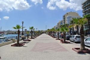 a sidewalk with palm trees and cars on a street at Modern 2BR Sliema Apartment in Sliema