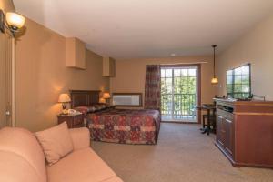 a bedroom with a bed and a desk in a room at Auberge du Lac Morency in Saint-Hippolyte