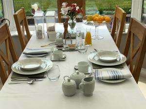 a white table with plates and glasses on it at Hysett House in Cocking