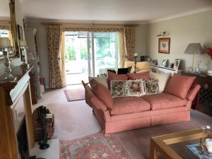 a living room with a red couch and a window at Hysett House in Midhurst