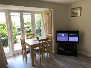 a dining room with a table and a television at Jubilee House in Oakham