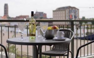 a table with a bottle of wine and glasses on a balcony at Appartment Ferienwohnung mit großer Terrasse Ohlerich Speicher Wismar in Wismar +10 photos